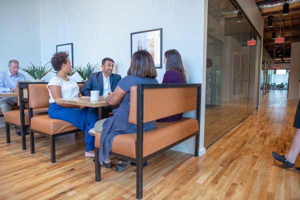 Group of multiple Gather Richmond co-workers networking around a lunch table