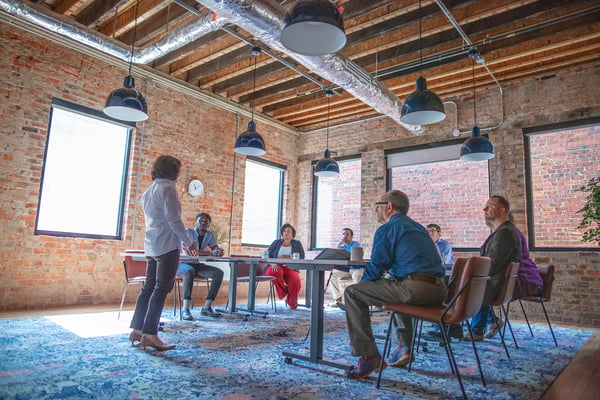 Gather co-worker presenting in a large industrial meeting space